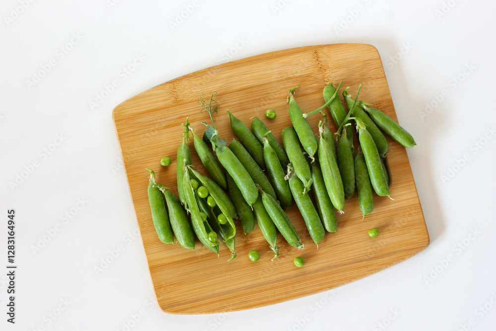 Fresh green peas on wooden cutting board: healthy eating concept Fresh green peas on wooden cutting board: healthy eating concept