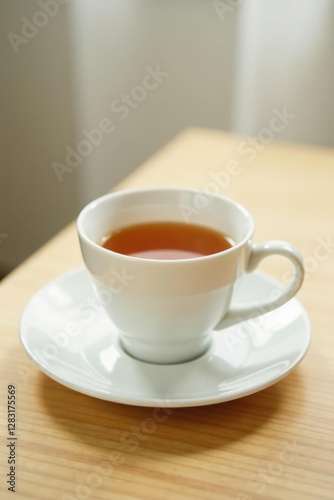 delicate white teacup and saucer resting on a light wooden table, serenity, gentle, saucer
