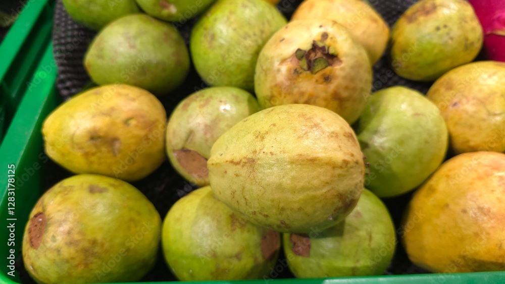 Fresh guava fruit with vibrant green skin and juicy pink flesh, sliced and arranged on a wooden surface. The tropical fruit is rich in vitamin C antioxidants, perfect for healthy eating natural food Fresh guava fruit with vibrant green skin and juicy pink flesh, sliced and arranged on a wooden surface. The tropical fruit is rich in vitamin C antioxidants, perfect for healthy eating natural food