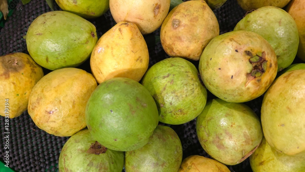 Fresh guava fruit with vibrant green skin and juicy pink flesh, sliced and arranged on a wooden surface. The tropical fruit is rich in vitamin C antioxidants, perfect for healthy eating natural food Fresh guava fruit with vibrant green skin and juicy pink flesh, sliced and arranged on a wooden surface. The tropical fruit is rich in vitamin C antioxidants, perfect for healthy eating natural food