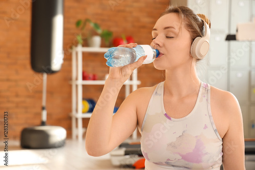 Sporty young woman drinking...