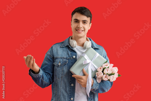 Young man with gift and flo...