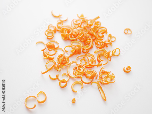 Dried orange peel curls on white background for culinary use