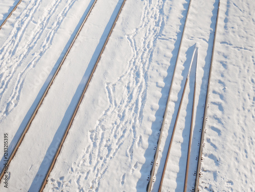 Railway tracks covered in snow during winter day