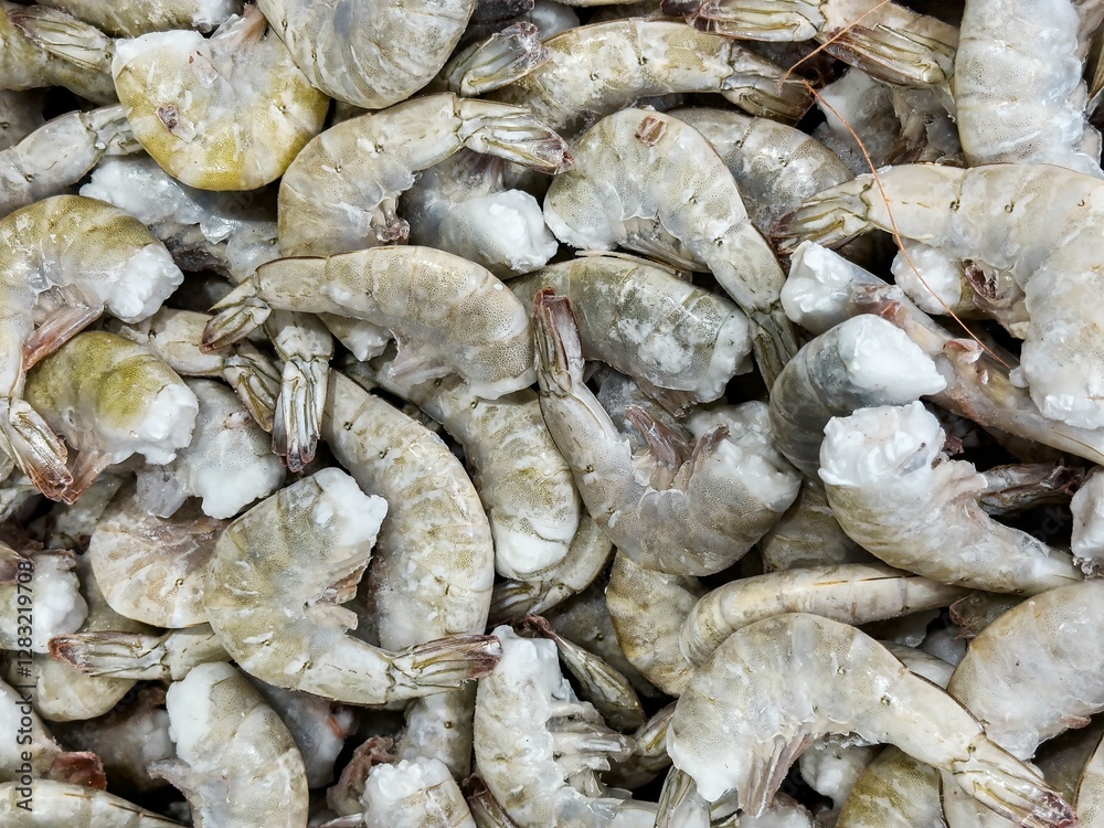 Fototapeta premium Fresh raw shrimp displayed on a market counter ready for purchase and cooking