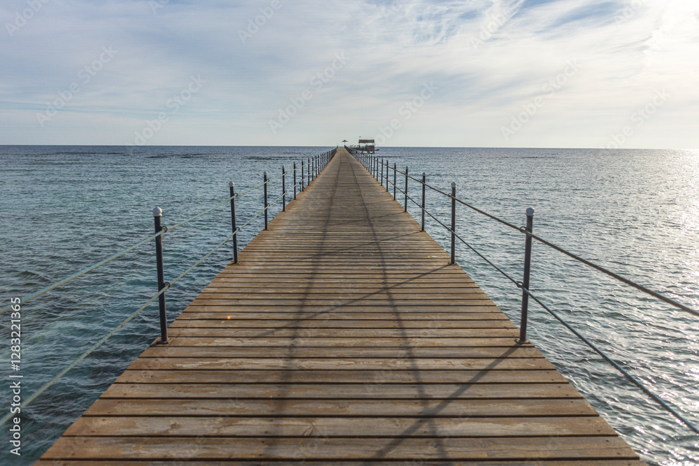 Long wooden pier stretching into the calm sea in marsa alam, egypt Long wooden pier stretching into the calm sea in marsa alam, egypt