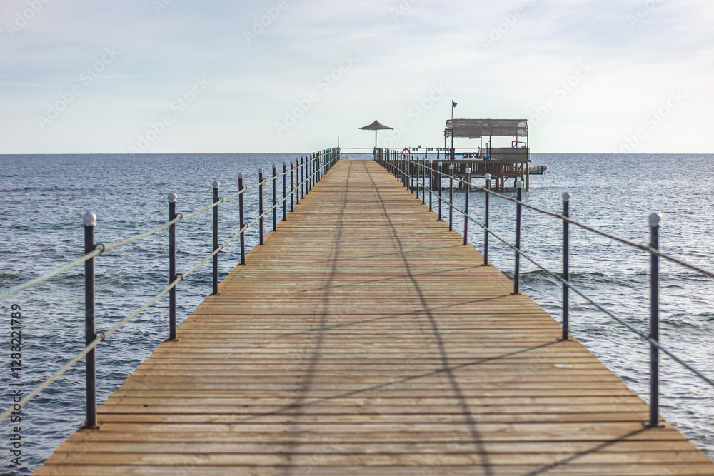 Long wooden pier stretching into the calm sea in marsa alam, egypt Long wooden pier stretching into the calm sea in marsa alam, egypt