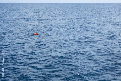 Orange lifebuoy floating on calm blue sea in marsa alam, egypt
