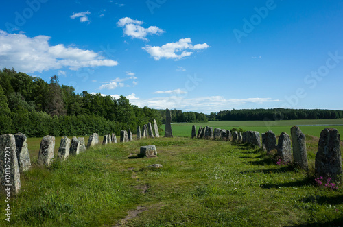 The Blomsholm stone ship (stenskeppet), one of Sweden’s largest prehistoric graves, set in a green field by the forest on a sunny summer day with a blue sky northeast of Strömstad