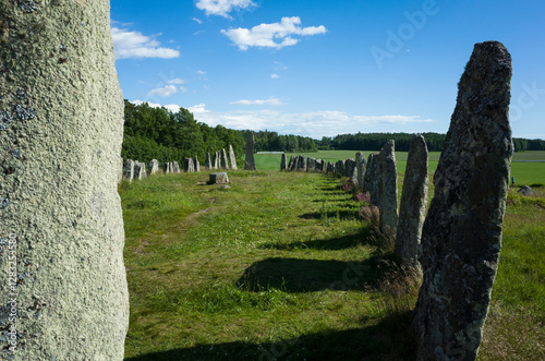 The Blomsholm stone ship, one of Sweden’s largest prehistoric graves, located near Strömstad. Ancient standing stones form a ship-like setting, captured on a sunny summer day with green fields photo