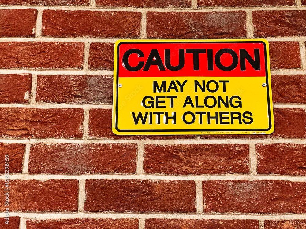 Caution sign displayed on a brick wall with an attention-grabbing message Caution sign displayed on a brick wall with an attention-grabbing message