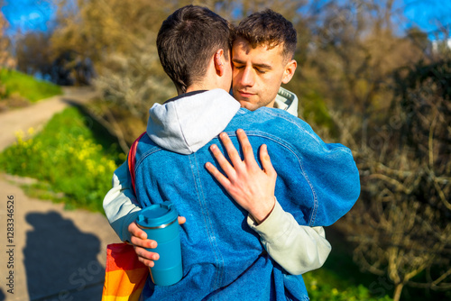 Young gay couple embracing in a park, celebrating love and pride
