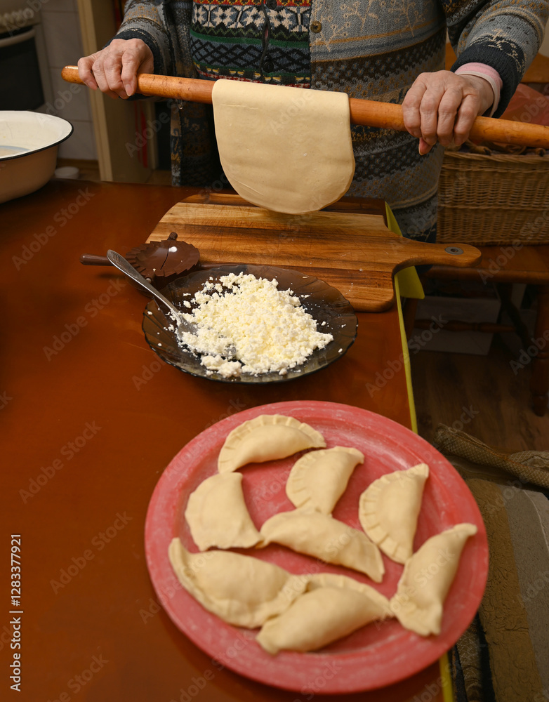 Preparation of traditional dumplings with cheese filling in a cozy kitchen setting