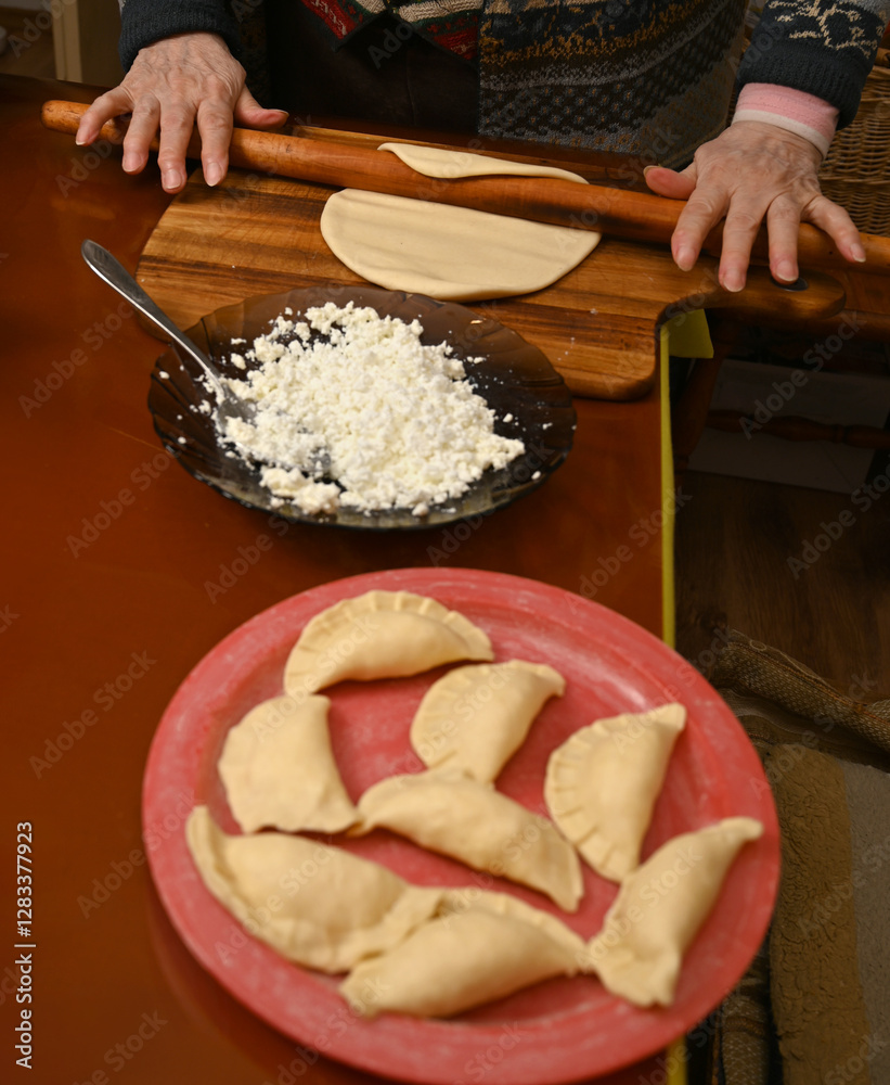 Homemade dumplings being prepared with cheese filling on a wooden surface in a cozy kitchen setting