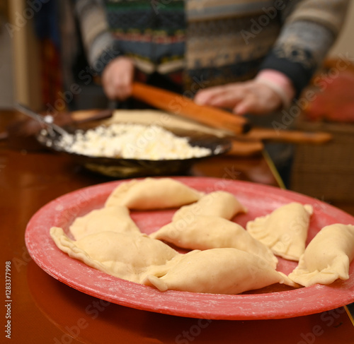 Obraz na płótnie Making traditional dumplings in a cozy kitchen during the afternoon with homemade filling prepared w salonie