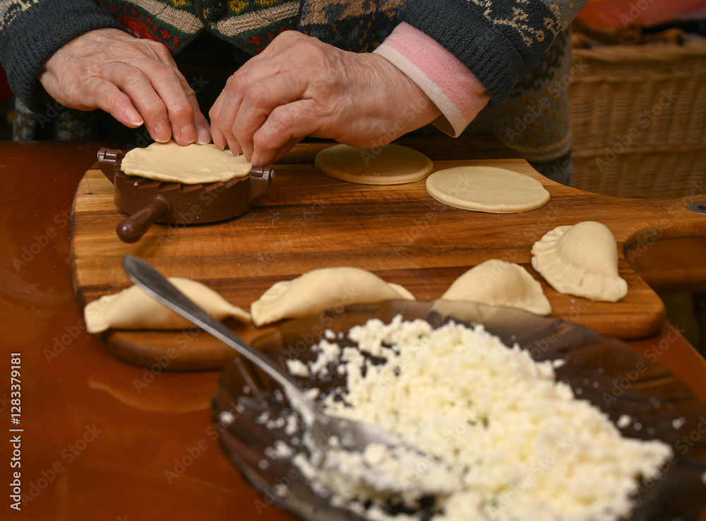 Woman skillfully fills dough circles with cheese in a warm kitchen