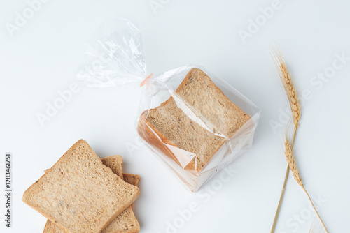 Freshly Baked Whole Grain Bread Slices Packed for Convenience in a Clear Plastic Bag With Wheat Stalks on a Clean Background