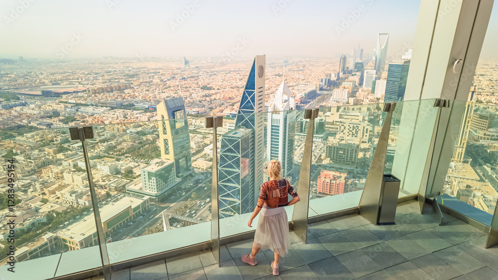 Tourist enjoying breathtaking panoramic views of Riyadh's skyline, featuring the iconic modern skyscrapers from a high vantage point