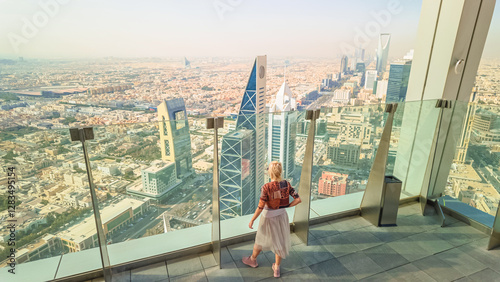 Tourist enjoying breathtaking panoramic views of Riyadh's skyline, featuring the iconic modern skyscrapers from a high vantage point