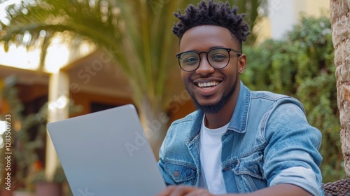 Young startupper in shirt and jeans with laptop.  photo