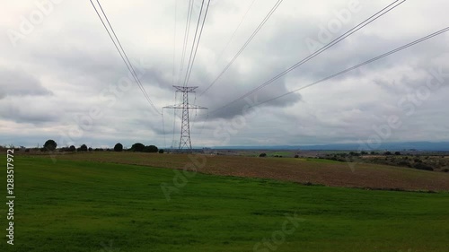 Panning below the electricity cable tower in cloudy day