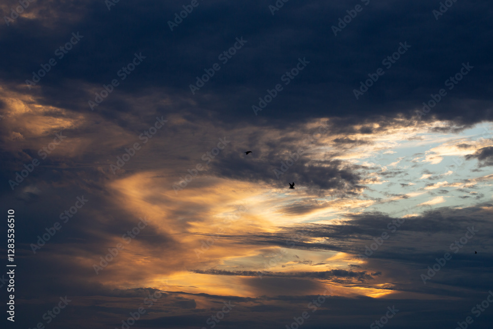 Beautiful dark colorful dramatic sky with clouds at sunset or sunrise.