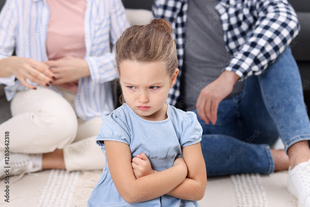 Resentful little girl and her parents at home. Family dispute Resentful little girl and her parents at home. Family dispute