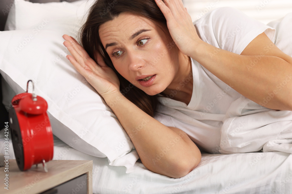 Overslept woman with alarm clock in bed at home Overslept woman with alarm clock in bed at home
