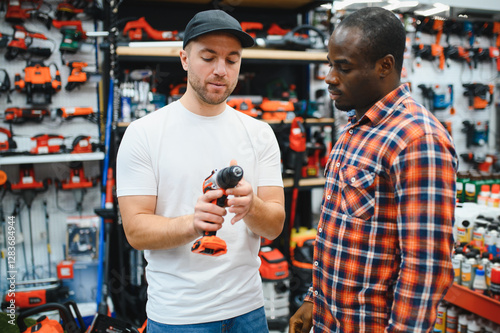 The seller helps the buyer choose a screwdriver in a hardware store. photo