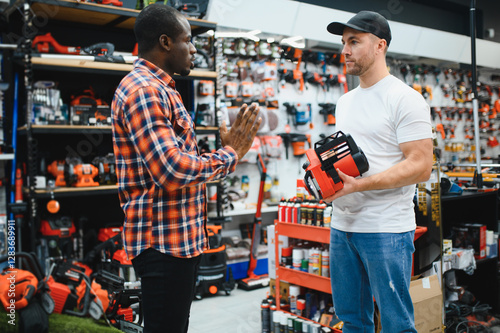 Fotografie A sales consultant helps a client choose an electric saw in a hardware store