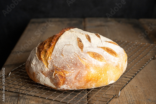 A homebaked artisan sourdough bread on a metal grate.