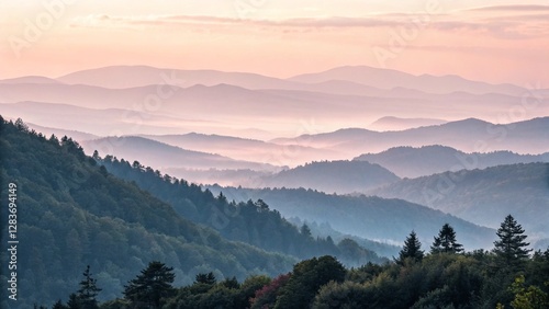 Panoramic view of a misty mountain range at dusk, with layers of forested hills disappearing into the fog under a gentle, colored sky, suitable for travel and nature stock photos