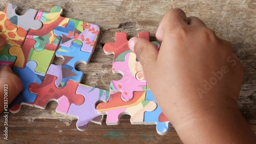 Close up of boy's hands playing jigsaw puzzle