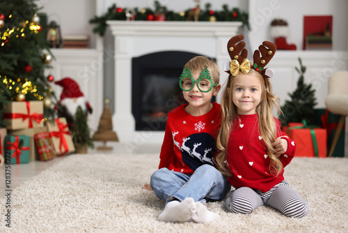 Cute little children in Christmas sweaters at home photo