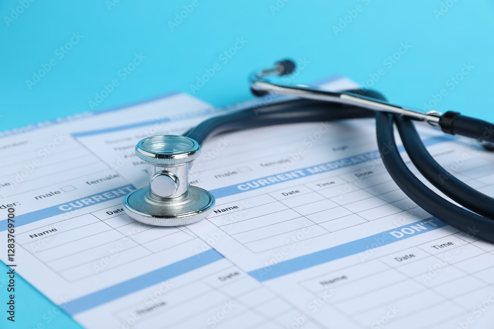 Stethoscope and medical card forms on light blue background, closeup Stethoscope and medical card forms on light blue background, closeup