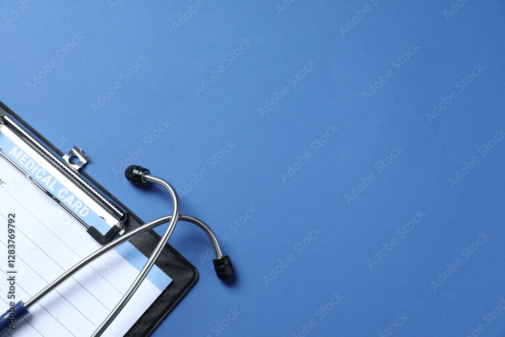 Stethoscope and medical card form on blue background, top view. Space for text