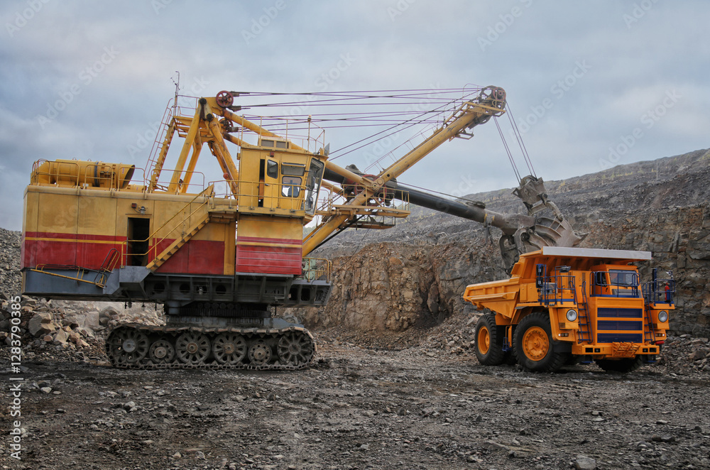 Industrial excavator loading ore into big yellow truck of quarry. Iron ore mining. No AI tools Industrial excavator loading ore into big yellow truck of quarry. Iron ore mining. No AI tools