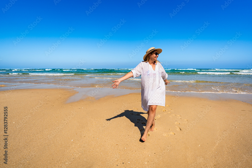 Happy middle-aged woman tourist enjoying sun and beautiful sandy beach on Armona island, Portugal. Front view Happy middle-aged woman tourist enjoying sun and beautiful sandy beach on Armona island, Portugal. Front view