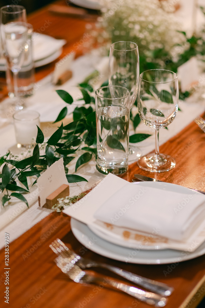 Fototapeta premium Elegant dining setup featuring greenery and glassware for a special celebration