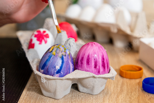 Family paints Easter eggs with a brush and paints, diy easter concept photo