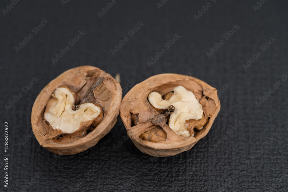 Obraz premium walnut and a cracked walnut isolated on the black background