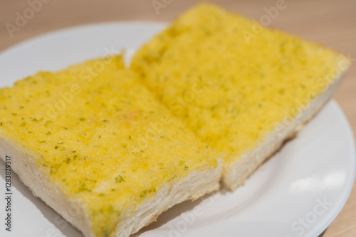 Garlic bread served on a white plate is a delicious and visually appealing dish.
