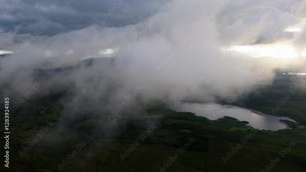 Clouds drift over the lush landscape and tranquil lake in the evening light, capturing the serene beauty of nature. Clouds drift over the lush landscape and tranquil lake in the evening light, capturing the serene beauty of nature.