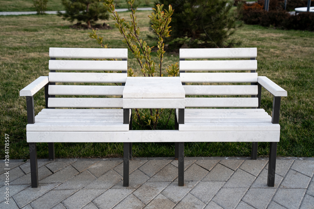 White wooden bench for two person with table in the park White wooden bench for two person with table in the park