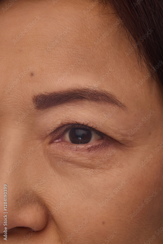 Fototapeta premium Close-up of Korean mature woman face, eye, eyebrow and cheeks. Healthy glow, soft skin texture, anti-aging skincare products. Concept of facial rejuvenation, wrinkle treatment, cosmetology