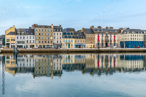 A view of shoreline buildings reflected in the water of the inner harbor  at Cherbourg, France in autumn