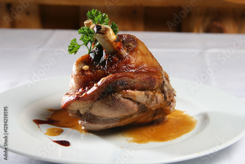 Roasted pork knuckle garnishing white plate, crispy golden-brown exterior, drizzling savory gravy, traditional german schweinshaxe delicacy photo