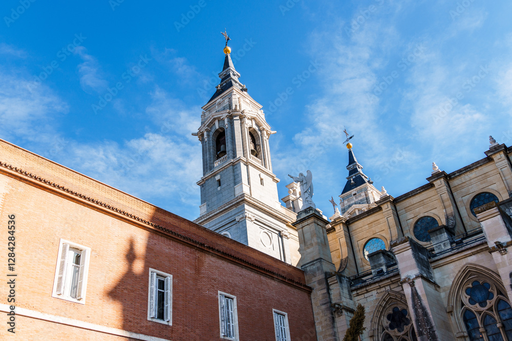 The Almudena Cathedral soars against the blue sky in Madrid, showcasing Spanish architecture.