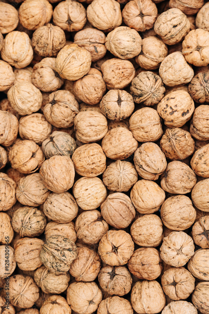 Pile of whole walnuts with textured shells. Natural organic nuts. Textured pile of whole walnuts with rough natural shells, creating an organic and rustic food composition Pile of whole walnuts with textured shells. Natural organic nuts. Textured pile of whole walnuts with rough natural shells, creating an organic and rustic food composition