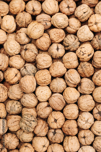 Pile of whole walnuts with textured shells. Natural organic nuts. Textured pile of whole walnuts with rough natural shells, creating an organic and rustic food composition